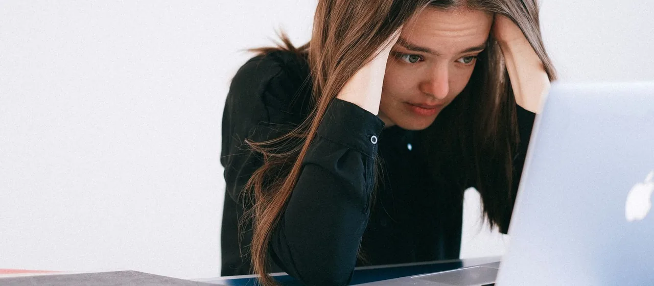 Vrouw ervaart stress achter haar laptop
