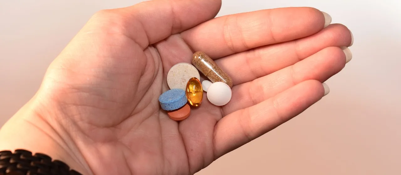 Close-up van een hand met medicatiecapsules